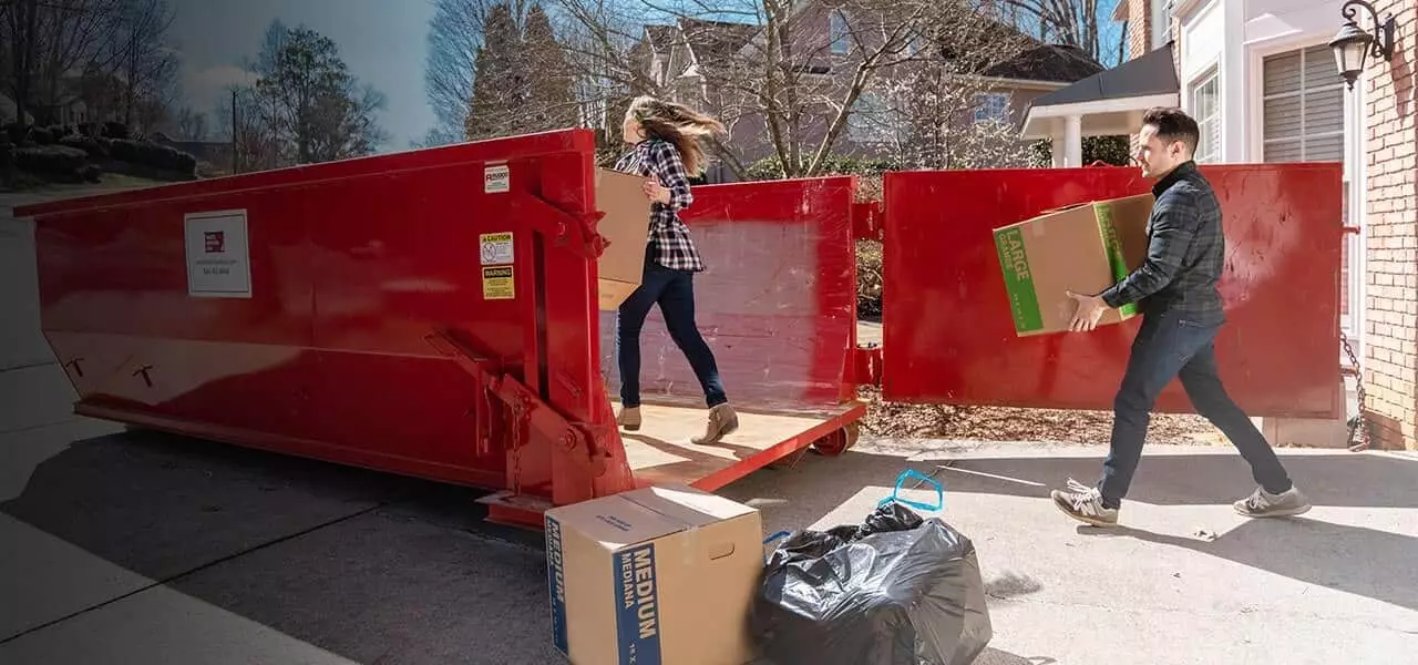 couple taking waste to red waste removal usa roll off dumpster